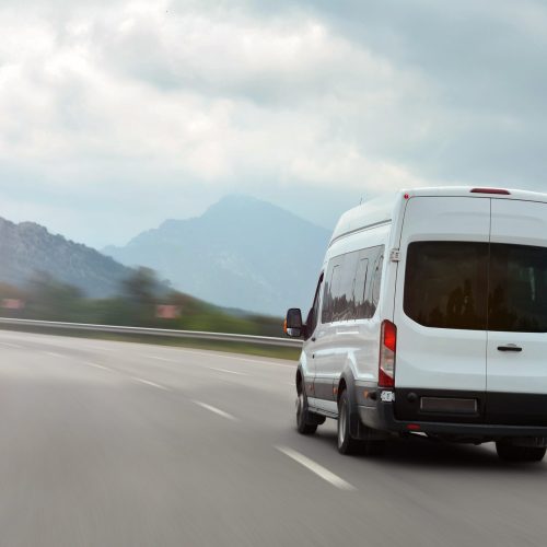 Passenger,Bus,Van,Accelerating,On,A,Background,Of,Mountains